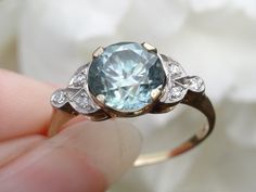 "Free shipping and complementary resize*! A subtle, bluish green. This antique blue zircon is more pastel in hue then most blue zircons. Yet, most blue zircons are heat treated and this one is likely a rarity and not treated.  In addition to the rare stone, the mount is also unique, in that it is made from a yellowish pinkish gold. Most zircons are usually set in platinum.  Zircons were often used in the earlier part of the last century. They lost popularity with the introduction of the similar-sounding, man-made \"zirconia.\"  Zircons are a natural gemstone which is a favorite of collectors, as they have an incredible sparkle that rivals diamonds and they are increasingly rare to find (especially in this size range). The zircon is a mesmerising 8.1-8.2mm and is set in a handmade mount, ma Blue Zircon Ring, Antique Brick, Antique Style Rings, Deco Blue, Rare Stone, Antique Blue, Bluish Green, Zircon Ring, Blue Zircon