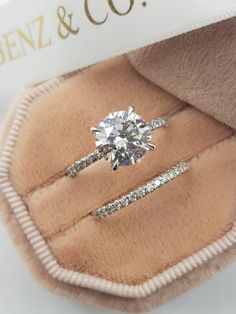 an engagement ring in a box with a label on it that says benzz & co