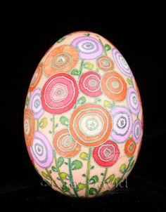 an egg decorated with flowers on a black background