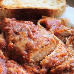 some meat and bread on a plate with tomato sauce in the middle, ready to be eaten