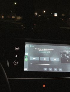 the dashboard of a car at night with an electronic device on it's display