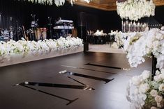 a black and white dance floor with flowers on the bottom, lights in the background