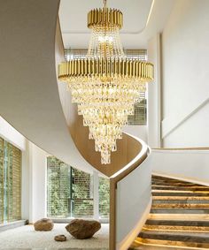 a large chandelier hanging from the ceiling in a room next to a spiral staircase