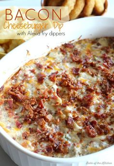 bacon cheeseburger dip in a white casserole dish next to crackers