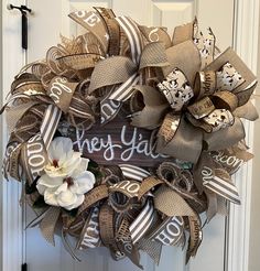 a wreath with the words hey yah on it and flowers in front of a door