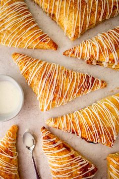 several pastries with white icing and a bowl of yogurt next to them