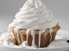 a white plate topped with a cupcake covered in frosting and icing on top of it