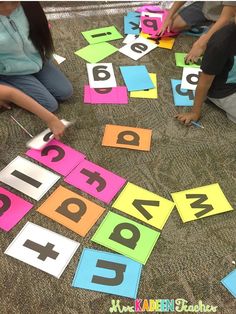 children are sitting on the floor playing with letters and numbers that spell out their name