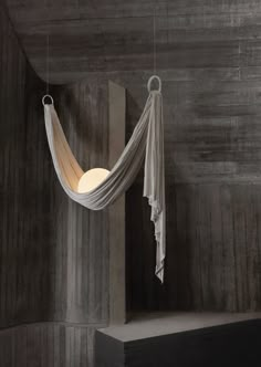 a hammock hanging from the ceiling in a room with concrete walls and flooring