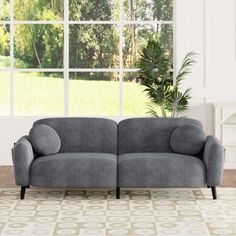 a gray couch sitting in front of a window