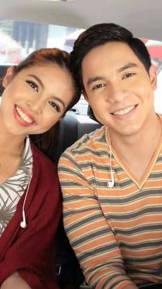 a man and woman sitting in the back seat of a car smiling at the camera