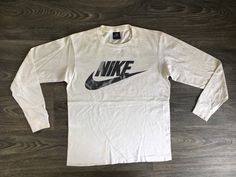 80's Blue Tag Nike Shirt. A classic longsleeve with a black & white color combo. There's some sweet distressing on the print. Some marks and one very small hole. Overall fair condition. 100% cotton that is soft and has that high-quality old cotton feel. Timeless Nike style. See more vintage Nike tees in my shop https://www.etsy.com/shop/sweetVTGtshirt?section_id=11916484&ref=shopsection_leftnav_4 Label: Nike Blue Tag. USA Made Measurements: Inches Chest/Bust: 18 1/2 Bottom Hem: 18 1/2 Sh Retro Long Sleeve Sports T-shirt, Retro Long Sleeve T-shirt With Logo Print, Vintage Long Sleeve Sports T-shirt, Sportswear Long Sleeve T-shirt With Logo Print, Vintage Long Sleeve Sports Top, Retro Long Sleeve T-shirt For Streetwear, Retro Long Sleeve Streetwear T-shirt, Retro Long Sleeve T-shirt For Sports Season, Nike Style