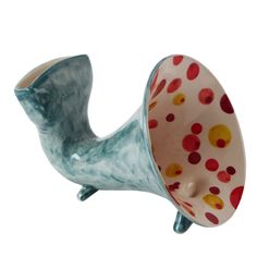 a ceramic object that is shaped like a bird with spots on it's body