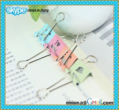 three pairs of paper clips sitting on top of an open book with the word love written in