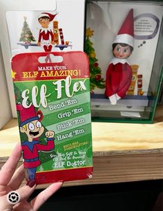 someone is holding up an elf flex toy in front of the elf's box