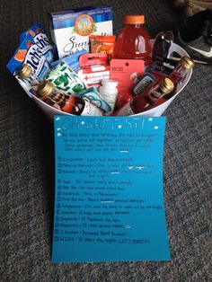 a basket filled with lots of food sitting on top of a floor next to a blue sign