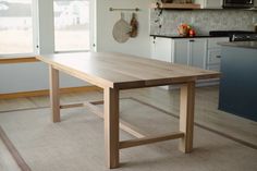 a wooden table sitting in the middle of a kitchen