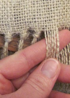 someone is stitching together some fabric with their fingers