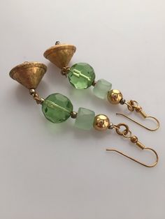 "Fun dangle pierced earrings in shades of green for Christmas time! The faceted green glass is accented with vintage satin glass as well as textured bell-shaped brass drops to add a little whimsy! Earrings measure 2.5\" long. One of a kind handcrafted earrings!" Vintage Gold Earrings For May Birthstone, Handmade Green Crystal Metal Earrings, Green Crystal Earrings For Jewelry Making, Nickel-free Green Beaded Earrings For Parties, Vintage Green Czech Glass Earrings, Green Metal Beaded Earrings For Party, Green Metal Earrings For Festive Occasions, Green Metal Beaded Party Earrings, Green Dangle Earrings For Festive Occasions