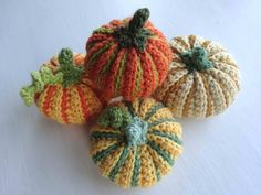 four crocheted pumpkins sitting on top of a table