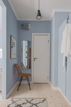 a room with blue walls and wooden floors has a rug on the floor next to it