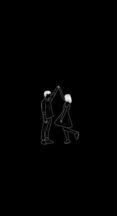 two people are standing in the dark with their arms around each other and one person is reaching for something