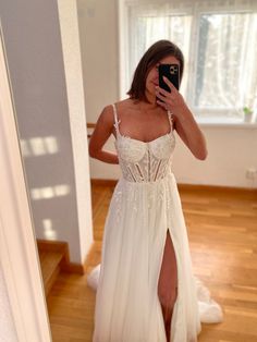 a woman in a white dress taking a selfie