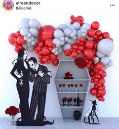 an image of a couple in front of balloons and shelves with wine glasses on them