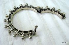 "VINTAGE ANTIQUE GREAT DESIGN TRIBAL OLD SILVER HINGE BRACELET BANGLE (KAKAN) FROM RAJASTHAN INDIA. Silver guard bangles (Khatria or bangri gokru) with hollow balls perimeters. Worn by DANGEE and PATEL tribal people of Rajasthan. One quarter-hinged part can be opened by central pin. Piece is good worn with a great antique look. See similar samples in\" Traditional jewelry of India\" by Oppi Untractht. Inner diameter - 6.3 cm(2.5\") Outer diameter - 10 cm(3.9\") Inner circumference - 19.8 cm(7.8\ Luxury Traditional Antique Silver Bracelet, Antique Silver Bangle For Festivals, Traditional Heavy Antique Silver Bangle, Antique Bangle For Rituals, Antique Silver Bangle For Festive Occasions, Traditional Antique Finish Bangle Jewelry, Antique Oxidized Bangle For Festivals, Traditional Antique Silver Bangle For Festivals, Antique Oxidized Bangle For Wedding