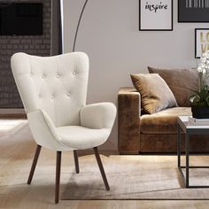 a living room with a couch, chair and coffee table in front of a brick wall