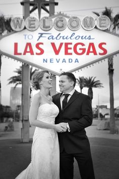 a bride and groom pose in front of the welcome sign to fabulous las vegas nevada