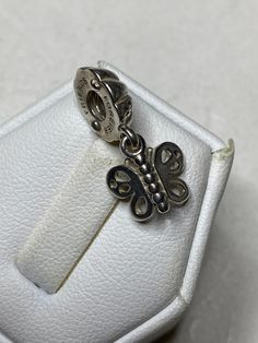 "The retired vintage Pandora \"Friends Forever\" butterfly charm is a beautiful and timeless piece of jewelry that makes for a thoughtful and sentimental gift for her. The charm is crafted from high-quality sterling silver, ensuring that it will last for years to come. As a vintage item, the charm may show some signs of wear and tear, which only adds to its charm and character. Despite this, the charm remains in good condition, ready to be added to her Pandora bracelet collection. The butterfly Elegant Silver Bracelet With Butterfly Charm, Silver Dainty Charms, Elegant Silver Charm Bracelet With Butterfly Charm, Elegant Butterfly Charms Jewelry, Silver Dainty Butterfly Bracelets, Elegant Silver Butterfly Bracelets, Dainty Silver Butterfly Bracelets, Dainty Silver Charms, Silver Elegant Charms For Gifts