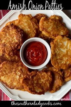 some fried food on a white plate with ketchup and sauce in the middle