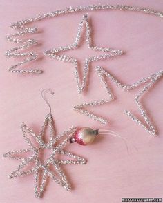 some ornaments are laying out on a pink surface