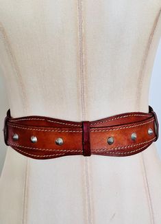 Description: Rare 1950s Women's Leather kidney belt - with Spike Studs!  Soft and supple leather waist cincher belt with scalloped edges and the coolest, baddest metal studs.  This belt has had a life (the stories it could tell!) - but despite its patina and age, it's quite wearable and sturdy. It has been conditioned with leather balm to keep it supple.  These belts are so hard to find, if it fit me I wouldn't be parting with it! :-)   Best fits a 24 - 26" waist.  Label: No Label  Fits like siz Leather Waist Cincher, Kidney Belt, 1950s Woman, Cincher Belt, Waist Cincher, Suspender Belt, Scalloped Edges, Suspenders, Leather Women