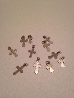 a group of small metal crosses sitting on top of a white table next to each other