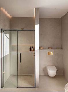 a bathroom with a glass shower door next to a toilet