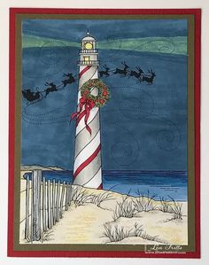 a christmas card with santa's sleigh in the sky and a lighthouse