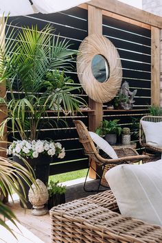 an outdoor patio with wicker furniture and potted plants