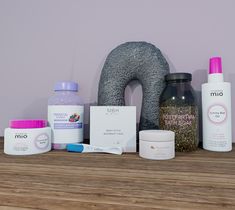 various skin care products are displayed on a wooden shelf next to a stuffed animal and an inflatable donut