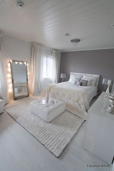 a bedroom with white furniture and lights on the ceiling