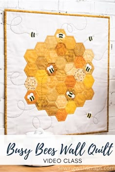 a quilted wall hanging on the side of a brick wall with bees and honeycombs