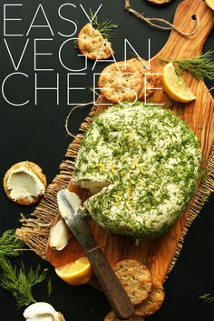 an easy vegan cheese board with crackers, lemons and herbs on it