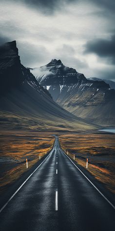 an empty road in the middle of nowhere, with mountains in the backgroud