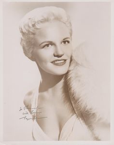 an old black and white photo of a woman with a fur stole around her neck