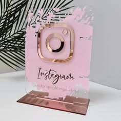 a pink instagram card with gold foil on it and a palm tree in the background