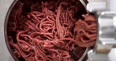 a large metal bowl filled with red meat