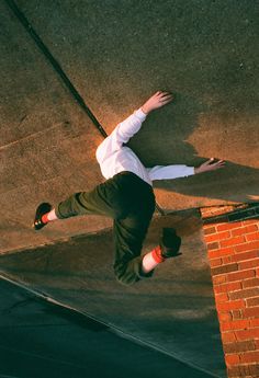 a man riding a skateboard up the side of a brick wall