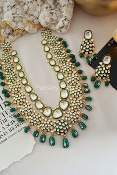 The majestically handcrafted green Polki necklace set is an ode to the Indian tradition and intricate work handcrafted by the artisans of India. The green meenakari work with shell pearls is a masterpiece inspired by Sabyasachi jewelry to give you a royal look. The bold and bright design of the necklace is perfect for all the beautiful brides to be!  Pair this replica of an ancestral jewelry necklace set with your ethnic or contemporary ensembles and create a look to remember.  Necklace Closure Traditional Green Hand Set Jewelry Sets, Traditional Green Hand Set Jewelry, Traditional Green Jewelry For Festive Occasion, Traditional Green Festive Jewelry, Traditional Emerald Necklaces For Gifts, Traditional Emerald Necklaces As Gifts, Green Temple Jewelry Sets For Gifts, Ceremonial Green Jewelry With Intricate Design, Green Temple Jewelry With Intricate Design