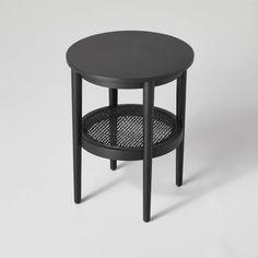 a black side table with a mesh shelf underneath it